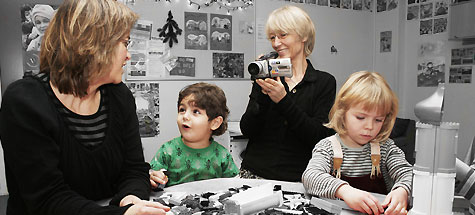 om-mig. Billede af Inger Hartelius der filmer pædagog og to børn i daginstitution.